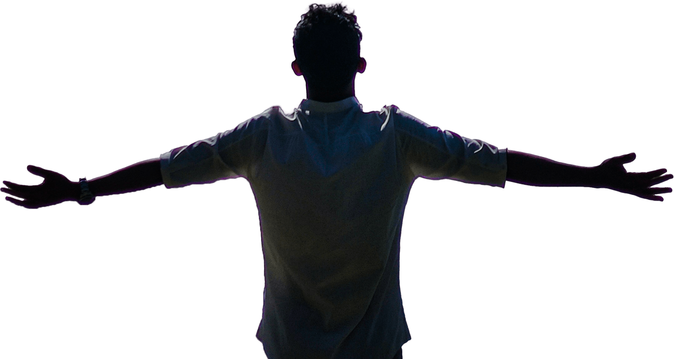 A person stands with arms outstretched, backlit against a dark backdrop, conveying a sense of openness and freedom.